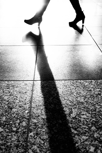 Silhouette of a woman in long boots walking