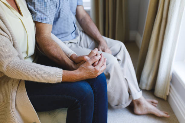 istock Senior caucasian couple sitting on sofa and holding hands 1338809301