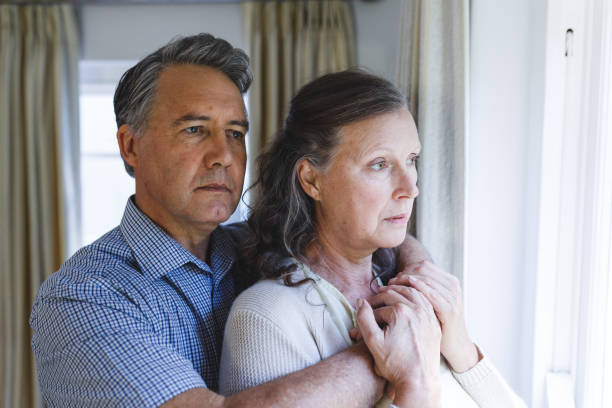 istock Thoughtful senior caucasian couple standing next to window, embracing 1338810167