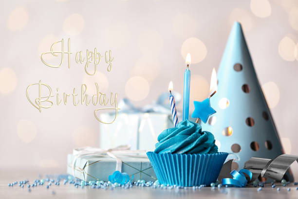 istock Delicious cupcake with burning candles and text Happy birthday on blurred background 1338810256