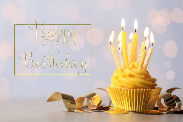 istock Delicious cupcake with burning candles and text Happy birthday on blurred background 1338810268