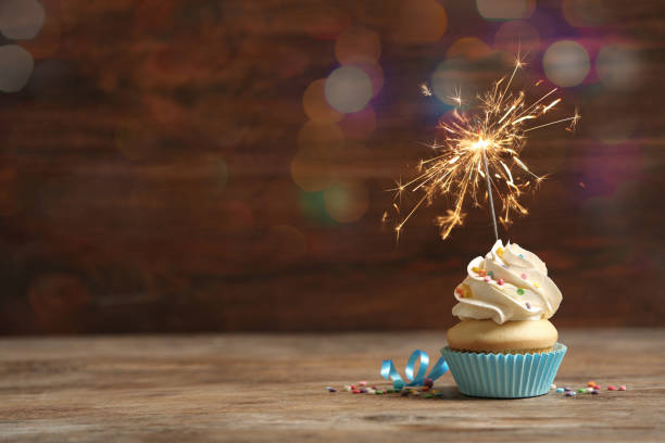 кекс на день рождения с бенгальским газом на деревянном столе, место для текста. эффект боке - cupcake cake birthday candy стоковые фото и изображения