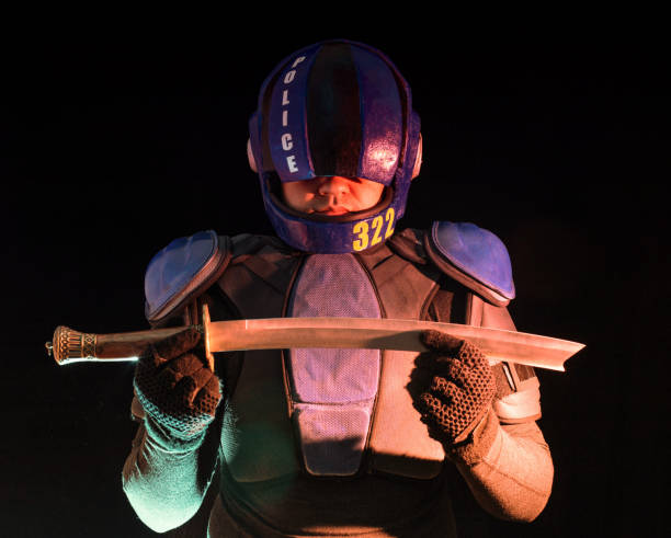istock Cyberpunk future concept. Bionic cyborg police officer with short samurai sword stands in dark. Halfman robot looks at camera. Futuristic science fiction scene. 1338813456