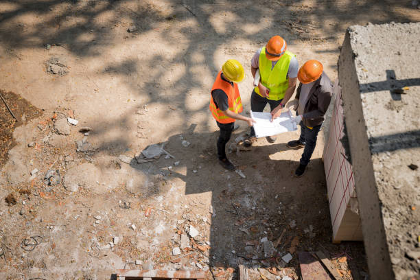 istock Team of construction workers discussing project details with executive supervisor in building construction site. 1338815592