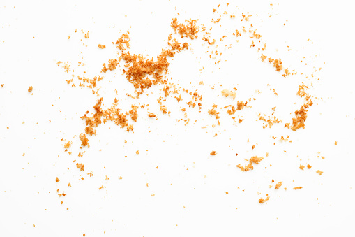 Overhead shot of bread crumbs on white background.
