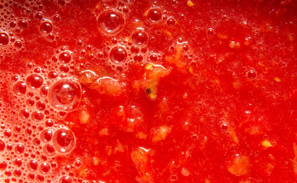 istock Tomato juice with pulp close-up. On the surface bubbles of different sizes and foam. 1338817514