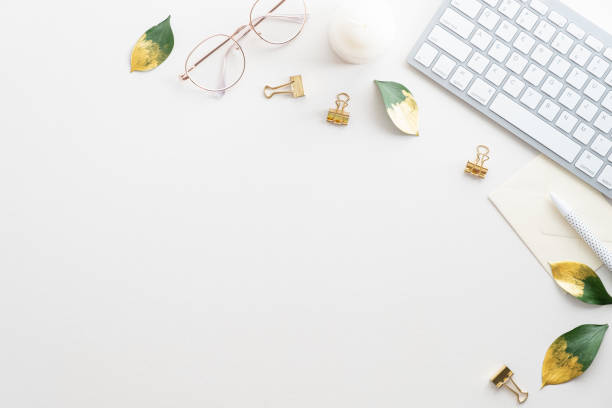 istock Feminine workspace with keyboard, glasses, fall leaves on white background. Home office desk table top view. Flat lay. 1338818303