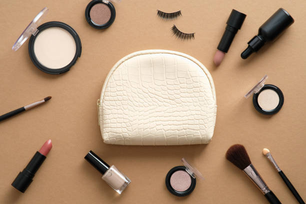 istock Clutch with makeup cosmetics and accessories on brown background. Flat lay, top view. 1338818906