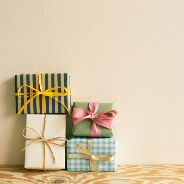istock Stack of gift boxes on wooden table. beige wall background 1338819317