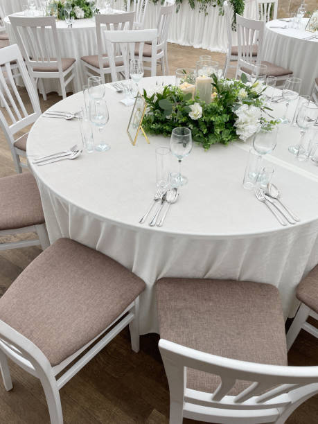 istock Beautifully decorated wedding table with white tablecloth, white blooming flowers, burning candles 1338820367