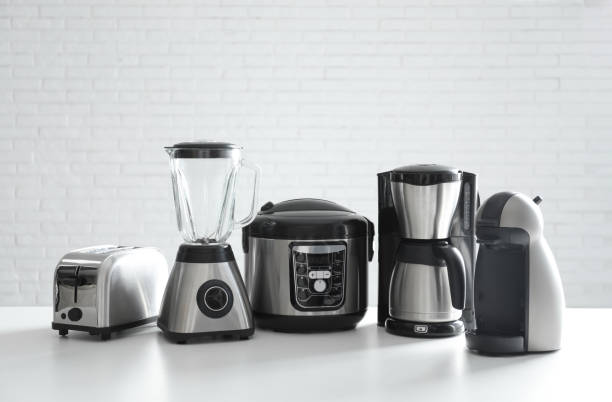 Set of modern home appliances on white table