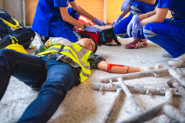 physical injury at work of construction worker. emergency medical teams are first aiding a construction worker who has an accident at a construction site. - civil building imagens e fotografias de stock