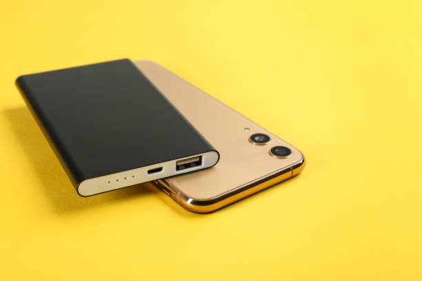 istock Mobile phone and portable charger on yellow background 1338822100