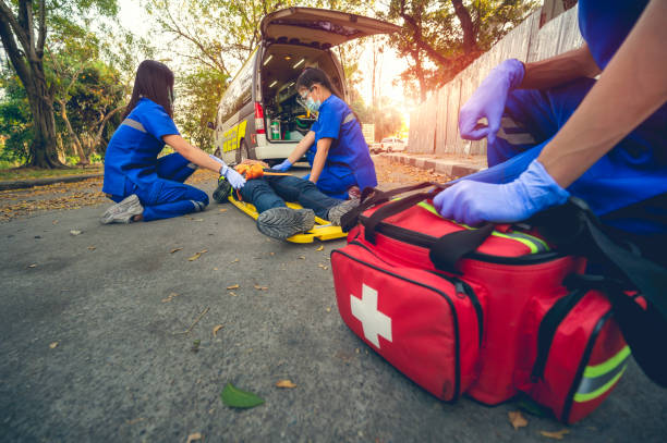 istock Emergency accident patient Suffered on head lying on stretcher. First aid training and move patient in emergency accident. Paramedic transfer patient to ambulance car. Select Focus on first aid bag. 1338822109