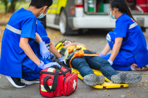 istock Emergency accident patient Suffered on head lying on stretcher. First aid training and move patient in emergency accident. Paramedic transfer patient to ambulance car. Select Focus on first aid bag. 1338822166