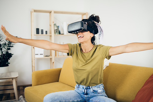 Portrait of a young woman having fun with a virtual reality headset at home.