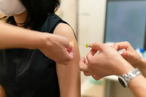 Photo of a woman being vaccinated by a doctor