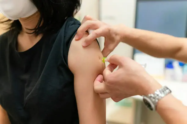 Photo of a woman being vaccinated by a doctor