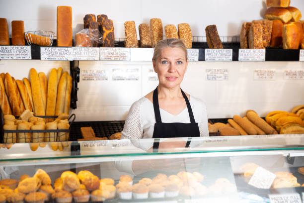 istock Female bakery employee offering bread and different pastry for sale 1338824719