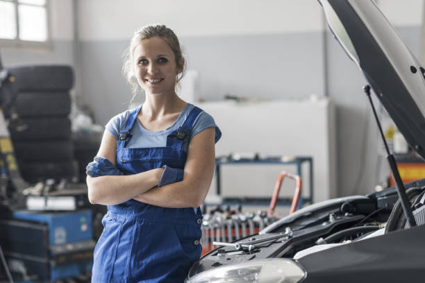 istock Female mechanic posing next to a car 1338828765