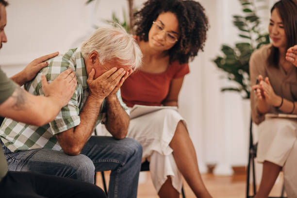 istock People consoling man at group therapy 1338828809