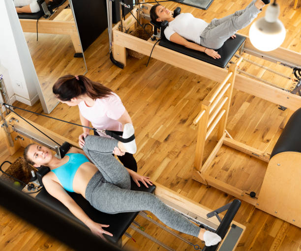 istock Top view of women practicing Pilates on reformer with trainer in studio 1338829661