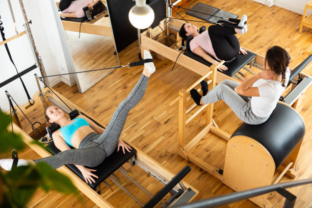 istock Fitness studio with women practicing Pilates on reformer 1338829669