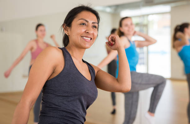 istock Cheerful hispanic woman practicing vigorous dance in group class 1338829751