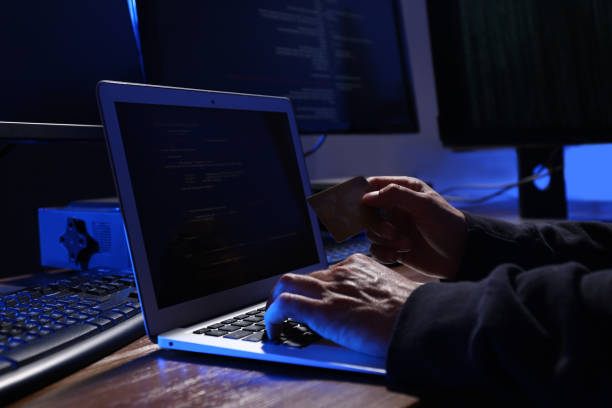 istock Hacker with computers and credit card in dark room, closeup. Cyber crime 1338830740
