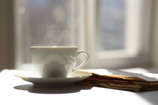 Delicious coffee and newspaper on sunlit table, space for text. Good morning
