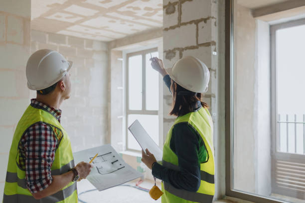 istock two engineers, a man and a woman in white helmets and green protective vests 1338833747