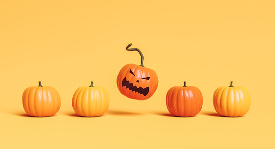 row of pumpkins with one of them jumping with angry face. concept of Halloween and arrival of autumn. 3d rendering