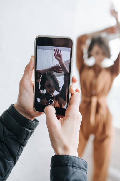 istock Male hands taking photo of a model with smartphone. Selective focus on screen. 1338834896