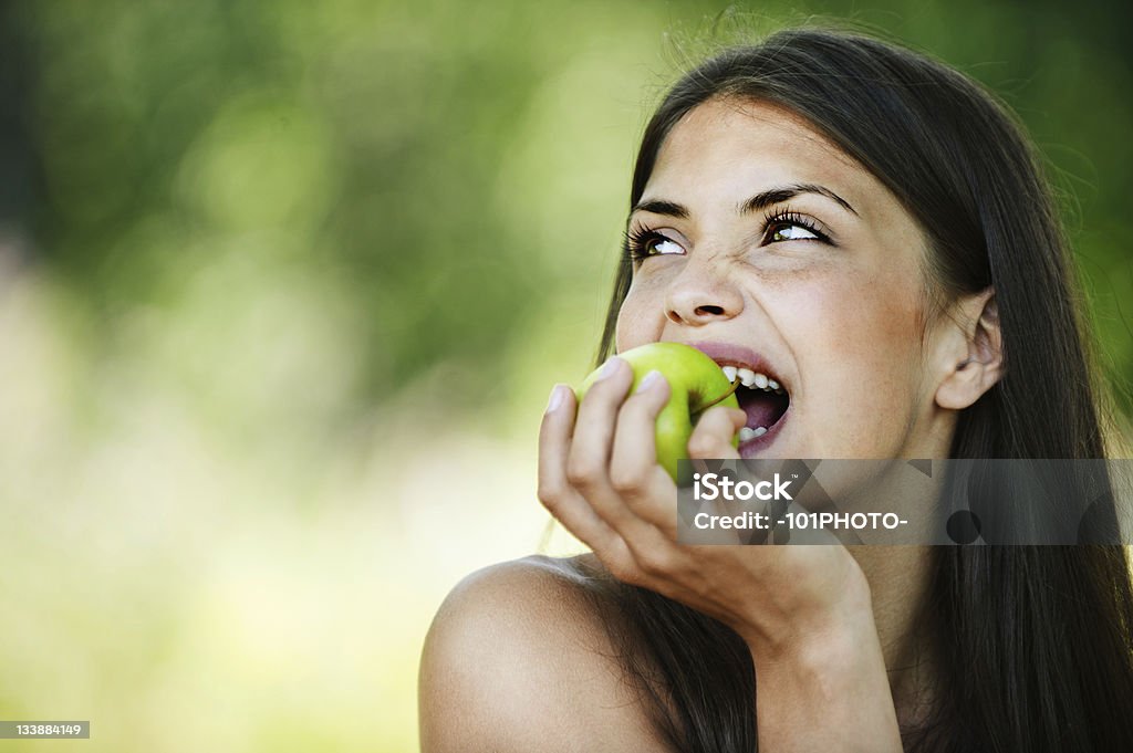 Ritratto di giovane affascinante donna Mordere apple - Foto stock royalty-free di Mela