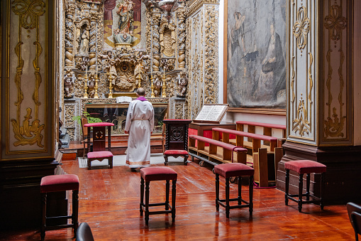 Priest in front of an altar in Igrejo Matriz de Sao Sebastio build in 1547 is the main church in Ponta Delgada on the Azorean Island San Miguel. The style is originally gothic but in the 18th century it was modernized in a more baroque style.