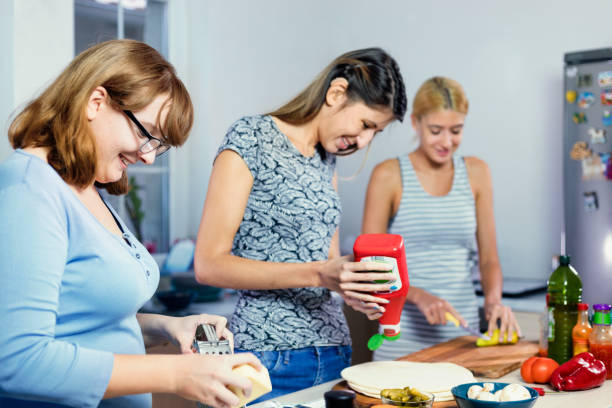 istock Friends Preparing Pizza for a Dinner Party 1338845663
