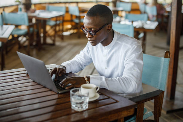 istock Black businessman working on laptop in a cafe. 1338845886