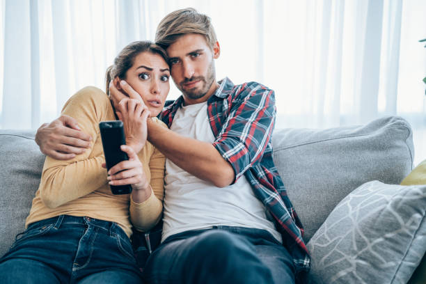 istock Cute young couple cuddling while watching tv. 1338846026