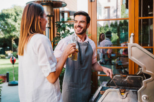 istock Young couple making barbecue in their garden. 1338846038