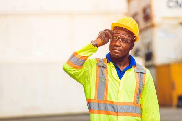 istock Black African happy worker working in logistic shipping standing confident smart looking containers at port cargo shipping work industry. 1338846205