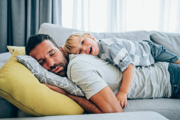 Father and little son at home. Shot of a father and his little boy spending time together at home. man sleeping top view stock pictures, royalty-free photos & images