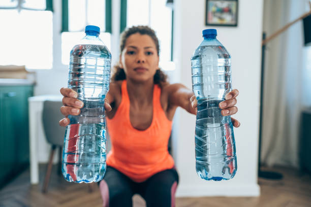 istock Woman workout at home with water bottles. 1338846817