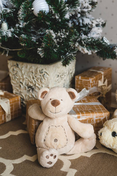 istock toy - bear cub near gift boxes under the Christmas tree 1338847196