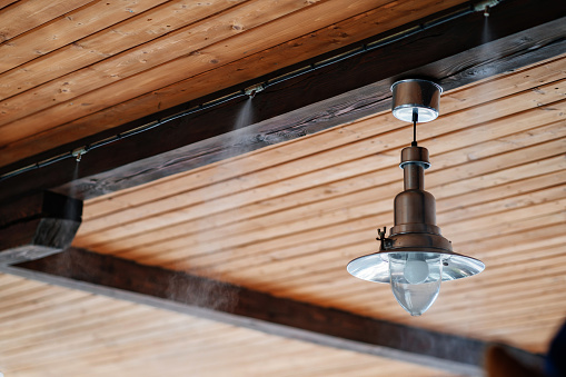 terrace ceiling with lamp and fog cooling system. comfortable stay outside in hot weather.