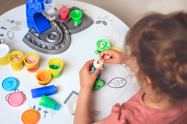 istock Little girl playing with clay making shapes 1338850181