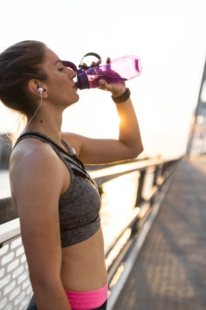 istock Thirsty female athlete drinking fresh water at the bridge 1338851454