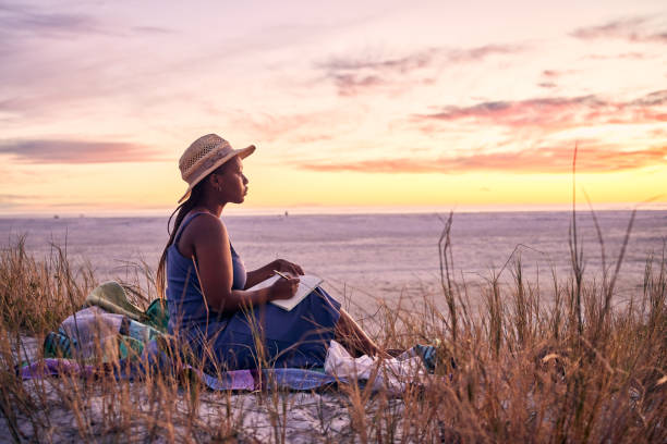 foto de una joven escribiendo en su diario en la playa - diary fotografías e imágenes de stock