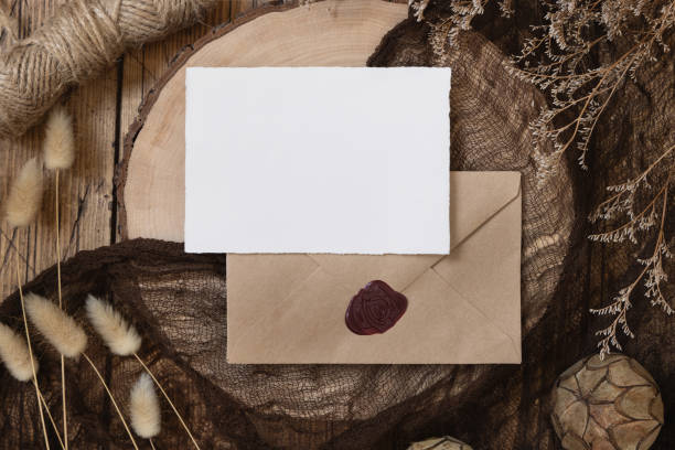 istock Blank paper card on sealed envelope and wooden table with dried plants 1338851752