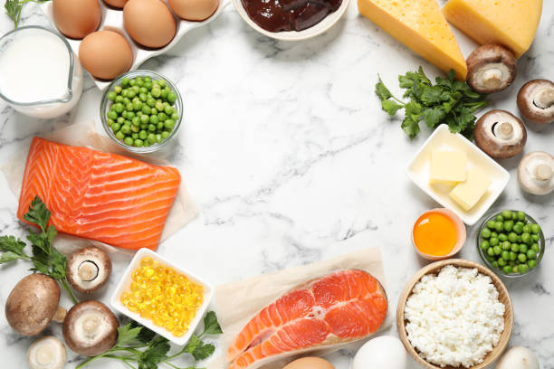 istock Flat lay composition with products rich in vitamin D on white marble table. Space for text 1338852088