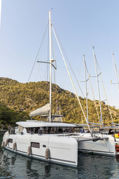 Catamaran type sailing boats Catamaran type sailing boats tied to a wooden pier in Gocek bay, Turkey. catamaran sailing stock pictures, royalty-free photos & images